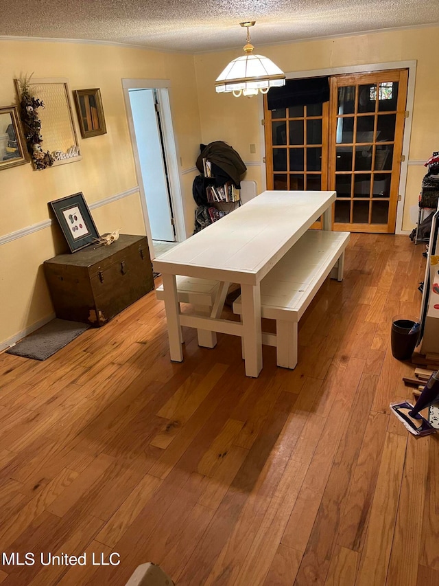 dining space with hardwood / wood-style flooring and a textured ceiling