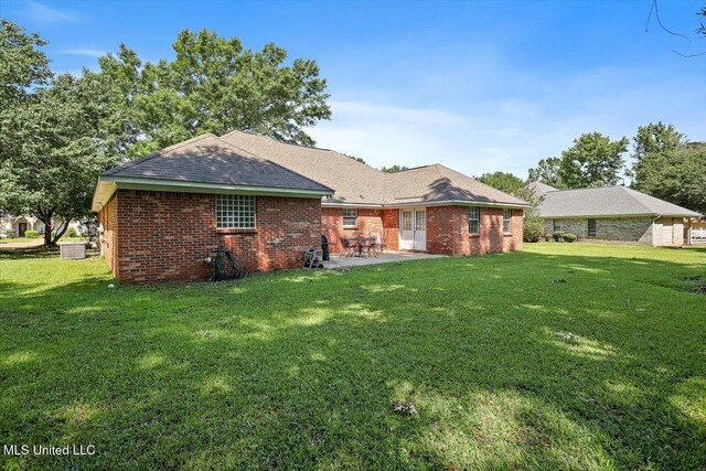 206 Southwind Dr, Richland, MS 39218 - back of house with a patio, brick siding, a lawn, and a shingled roof