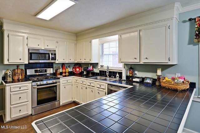 206 Southwind Dr, Richland, MS 39218 - kitchen featuring stainless steel appliances, tile countertops, a sink, crown molding, and a peninsula