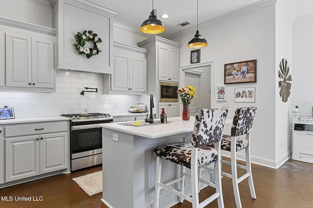 kitchen with gas range, white cabinetry, black microwave, a kitchen breakfast bar, and a kitchen island