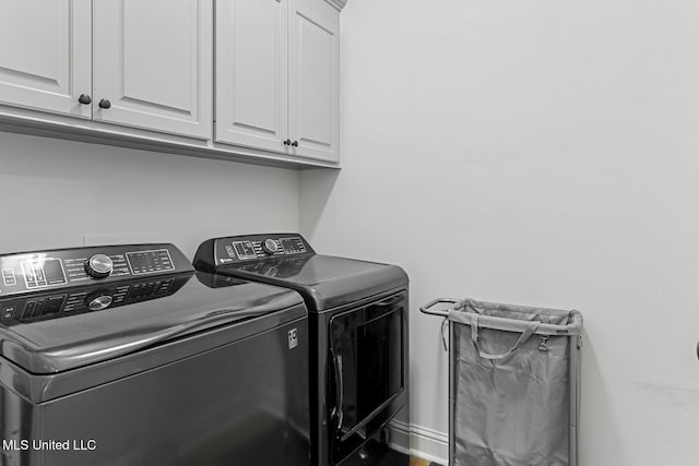 clothes washing area featuring cabinets and independent washer and dryer