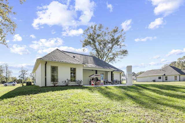 back of house with a yard and a patio