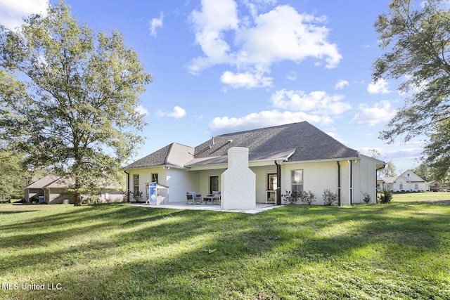 rear view of property with a yard and a patio