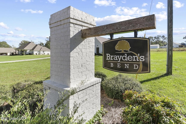 community / neighborhood sign featuring a lawn