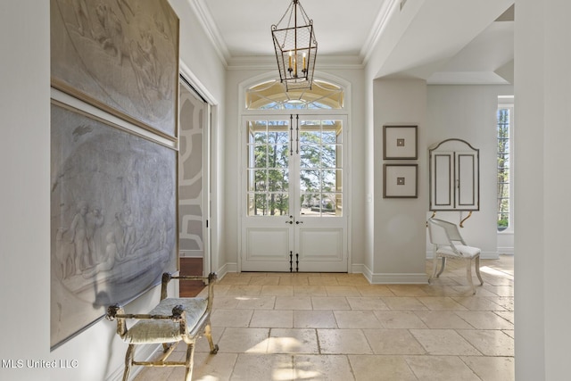 foyer featuring ornamental molding, a notable chandelier, and french doors