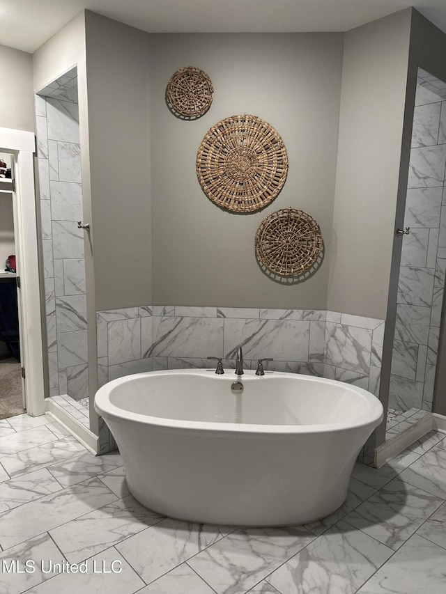 bathroom with a tub and tile walls