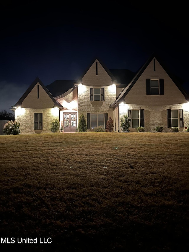 view of front facade with french doors and a lawn