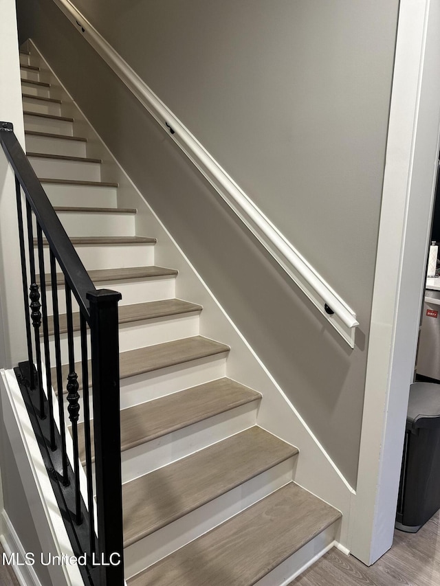 stairway with hardwood / wood-style flooring