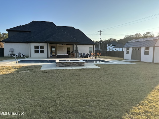 back of property with a storage shed, a yard, and a patio area