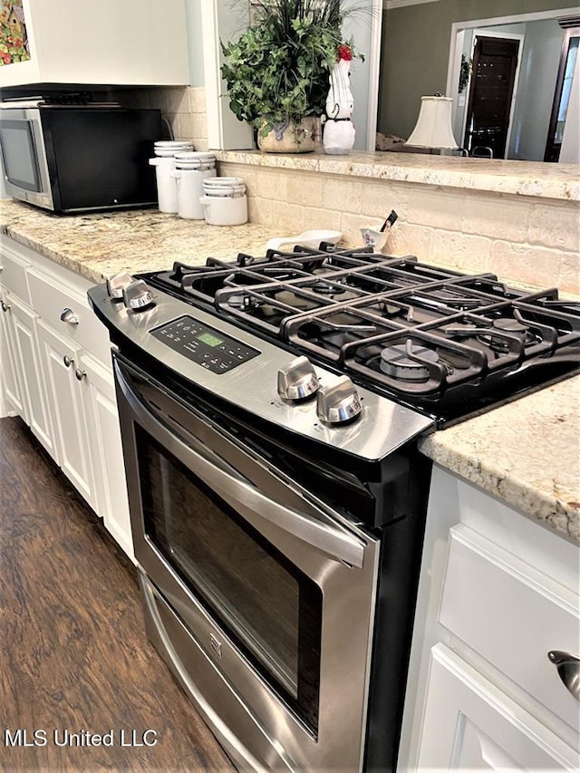 210 Jefferson Davis Blvd, Natchez, MS 39120 - kitchen featuring stainless steel appliances, backsplash, dark wood-style floors, white cabinets, and light stone countertops