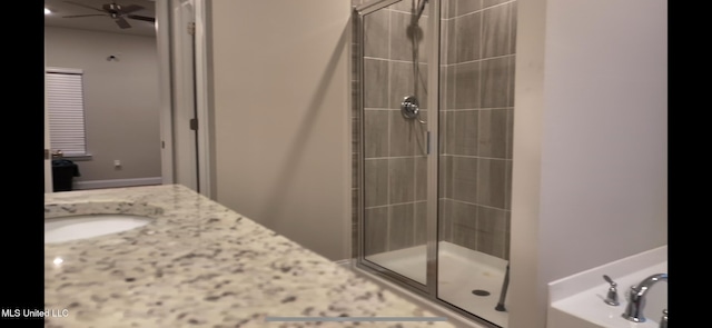 bathroom with ceiling fan, vanity, and an enclosed shower