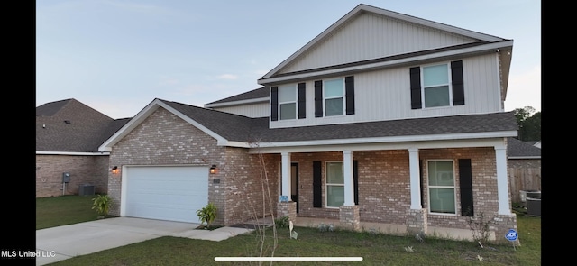 view of front of home with covered porch, a garage, central AC, and a front lawn