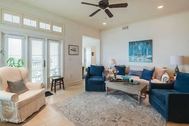 living room featuring ornamental molding, a ceiling fan, visible vents, and light tile patterned floors