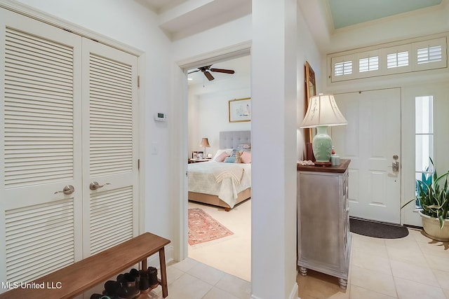 foyer featuring ceiling fan and ornamental molding