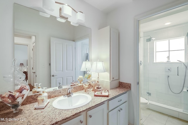 full bath with toilet, tile patterned floors, vanity, a shower stall, and a closet