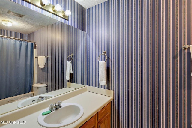 2120 Meagan Dr, Byram, MS 39272 - full bath featuring wallpapered walls, vanity, a textured ceiling, and a shower with shower curtain