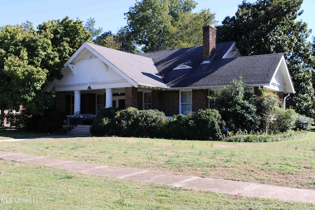 245 E College Ave, Holly Springs, MS 38635 - view of front of home featuring a chimney, a front lawn, covered porch, brick siding, and a shingled roof