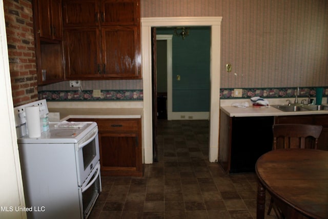 245 E College Ave, Holly Springs, MS 38635 - kitchen featuring white electric range, wallpapered walls, a sink, and light countertops