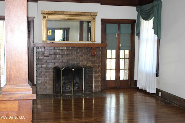 245 E College Ave, Holly Springs, MS 38635 - unfurnished living room featuring a brick fireplace, wood finished floors, and french doors