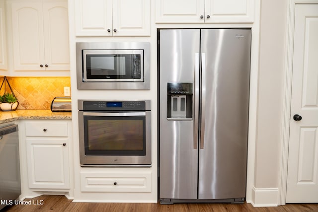105 Bridgeton Way, Canton, MS 39046 - kitchen featuring stainless steel appliances, wood finished floors, light stone counters, decorative backsplash, and white cabinetry