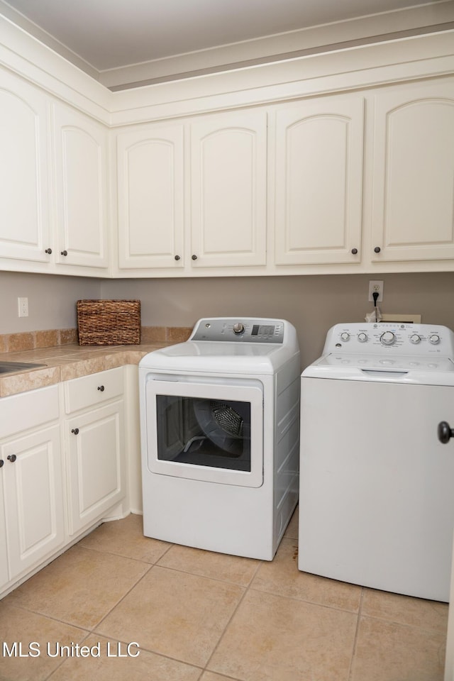 105 Bridgeton Way, Canton, MS 39046 - laundry area featuring cabinet space, separate washer and dryer, and light tile patterned floors