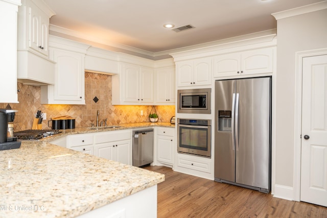 105 Bridgeton Way, Canton, MS 39046 - kitchen featuring stainless steel appliances, light stone counters, recessed lighting, light wood finished floors, and ornamental molding