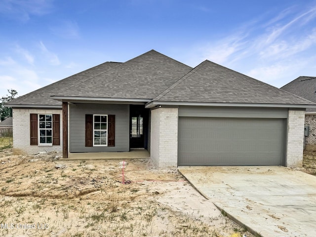 354 Willow Way, Canton, MS 39046 - view of front facade featuring brick siding, roof with shingles, an attached garage, and concrete driveway