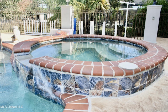 view of pool with pool water feature and an in ground hot tub