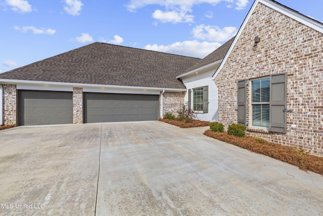 ranch-style house with concrete driveway, brick siding, and roof with shingles