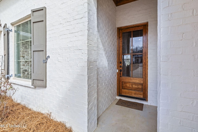 doorway to property featuring brick siding