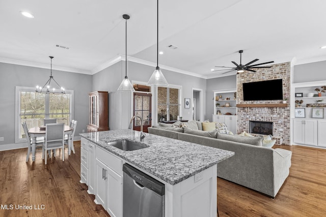 kitchen featuring built in shelves, dark wood-style floors, visible vents, stainless steel dishwasher, and a sink