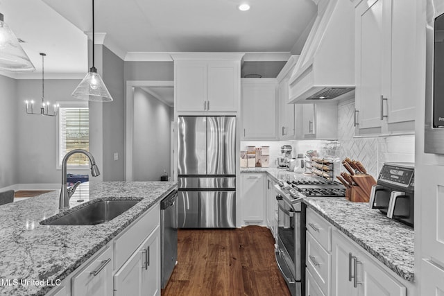 kitchen with a sink, white cabinets, custom range hood, appliances with stainless steel finishes, and crown molding