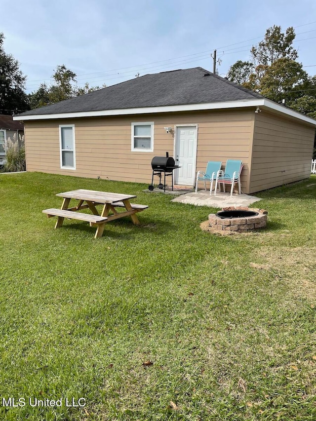 back of house with a patio area, a fire pit, and a yard