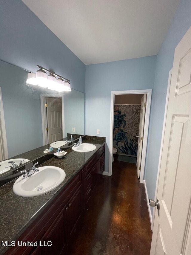 bathroom with vanity, toilet, and concrete floors