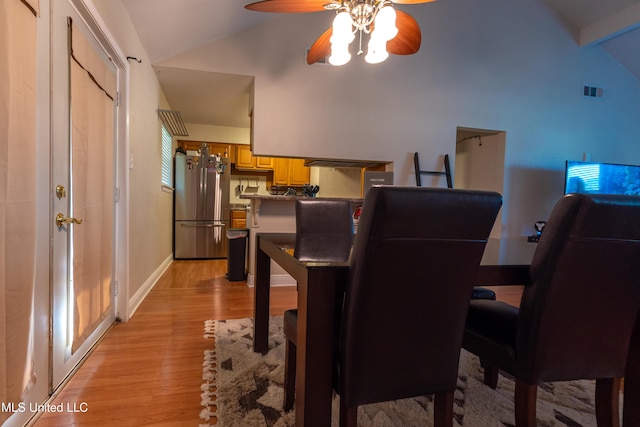 dining room with visible vents, a ceiling fan, vaulted ceiling, light wood-type flooring, and baseboards