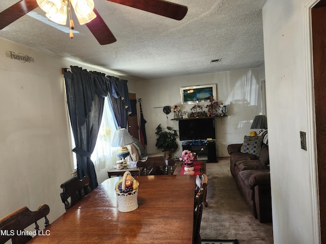 carpeted dining area featuring a textured ceiling and ceiling fan