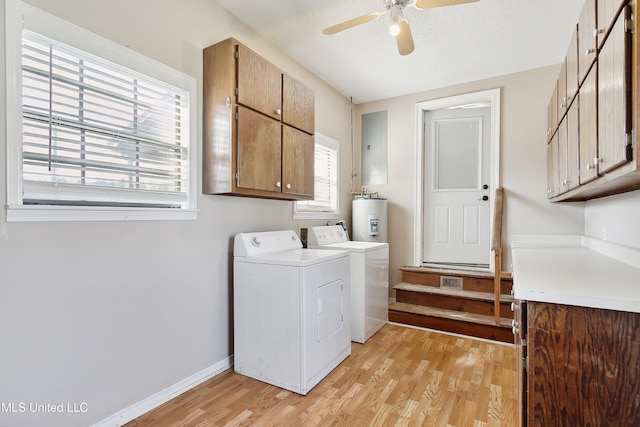 clothes washing area with light hardwood / wood-style floors, a wealth of natural light, cabinets, and washing machine and clothes dryer