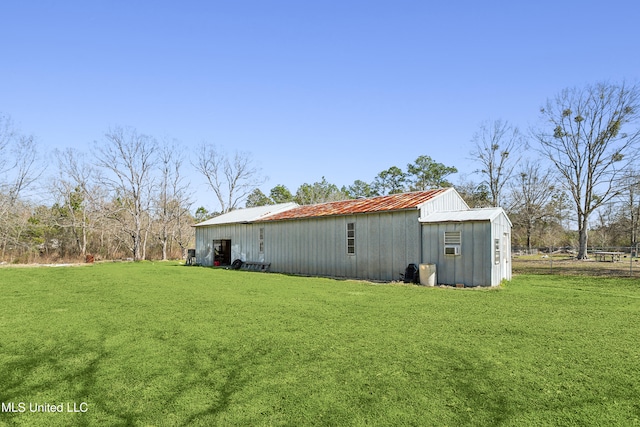 view of side of home with a yard and an outdoor structure