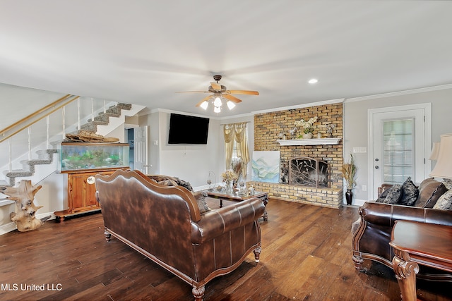 living room with a fireplace, wood-type flooring, ceiling fan, and crown molding