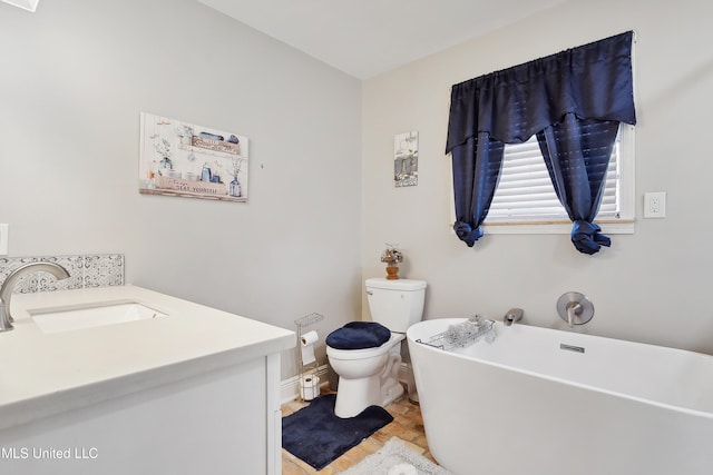 bathroom with toilet, vanity, and a bathing tub