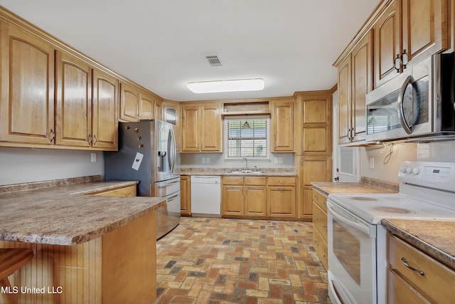 kitchen featuring stainless steel appliances, a breakfast bar area, and sink