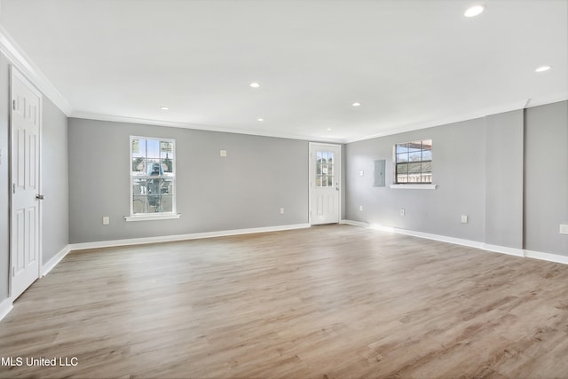 unfurnished room featuring plenty of natural light, light hardwood / wood-style flooring, and crown molding