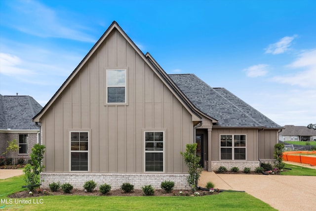 3755 Roland Dr, Southaven, MS 38672 - view of front facade with board and batten siding, a shingled roof, and a front lawn