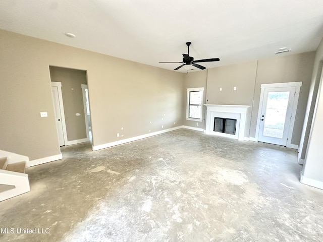 3755 Roland Dr, Southaven, MS 38672 - unfurnished living room featuring unfinished concrete flooring, a ceiling fan, plenty of natural light, and a glass covered fireplace