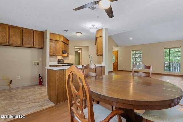 dining area with visible vents, vaulted ceiling, baseboards, and ceiling fan