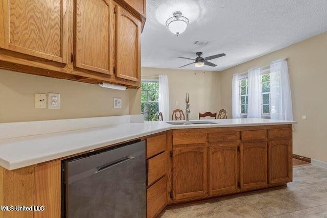 kitchen with visible vents, stainless steel dishwasher, brown cabinetry, a sink, and a peninsula