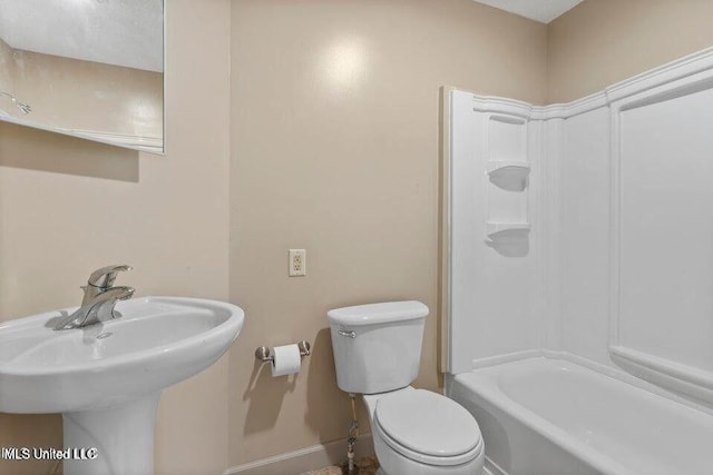 bathroom with washtub / shower combination, baseboards, a sink, and toilet