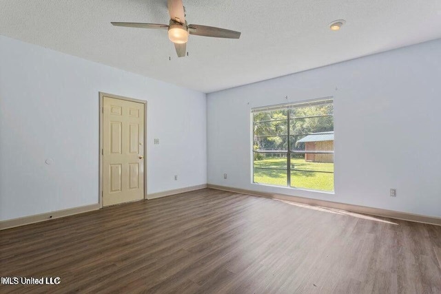 spare room with ceiling fan, a textured ceiling, baseboards, and wood finished floors