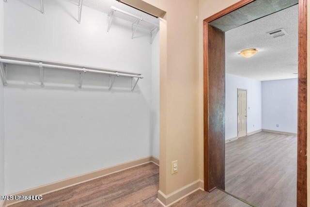 walk in closet featuring wood finished floors and visible vents