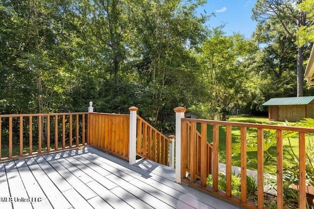 wooden terrace with an outbuilding, a yard, and a storage unit